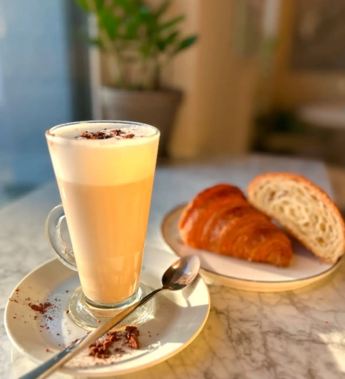 Latte i croissant w porannym świetle w Prego Caffe